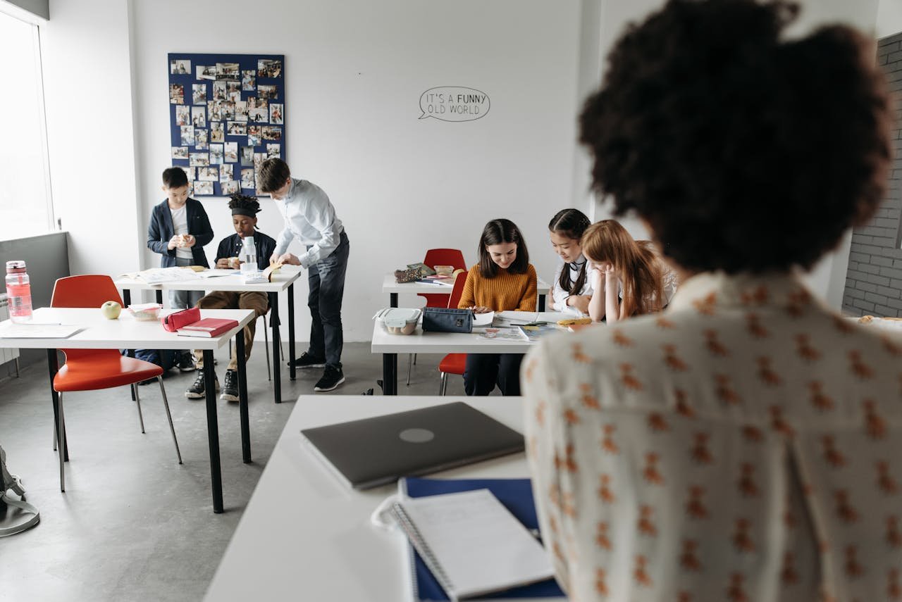 Students focused in a modern classroom with diverse activities and interactions.